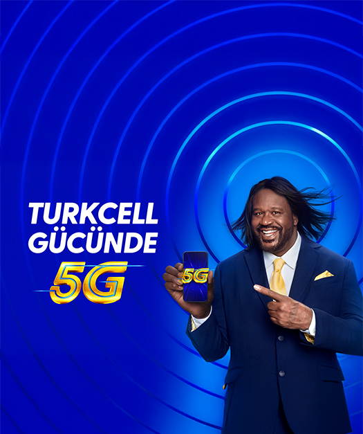 Takım elbiseli Shaquille O'Neal'ın 5G telefon gösterdiği Turkcell Gücünde 5G afişi.